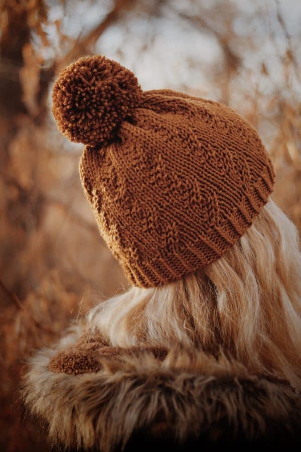 Woman wearing cream Prairie Beanie with faux cable knit texture and cozy sweater