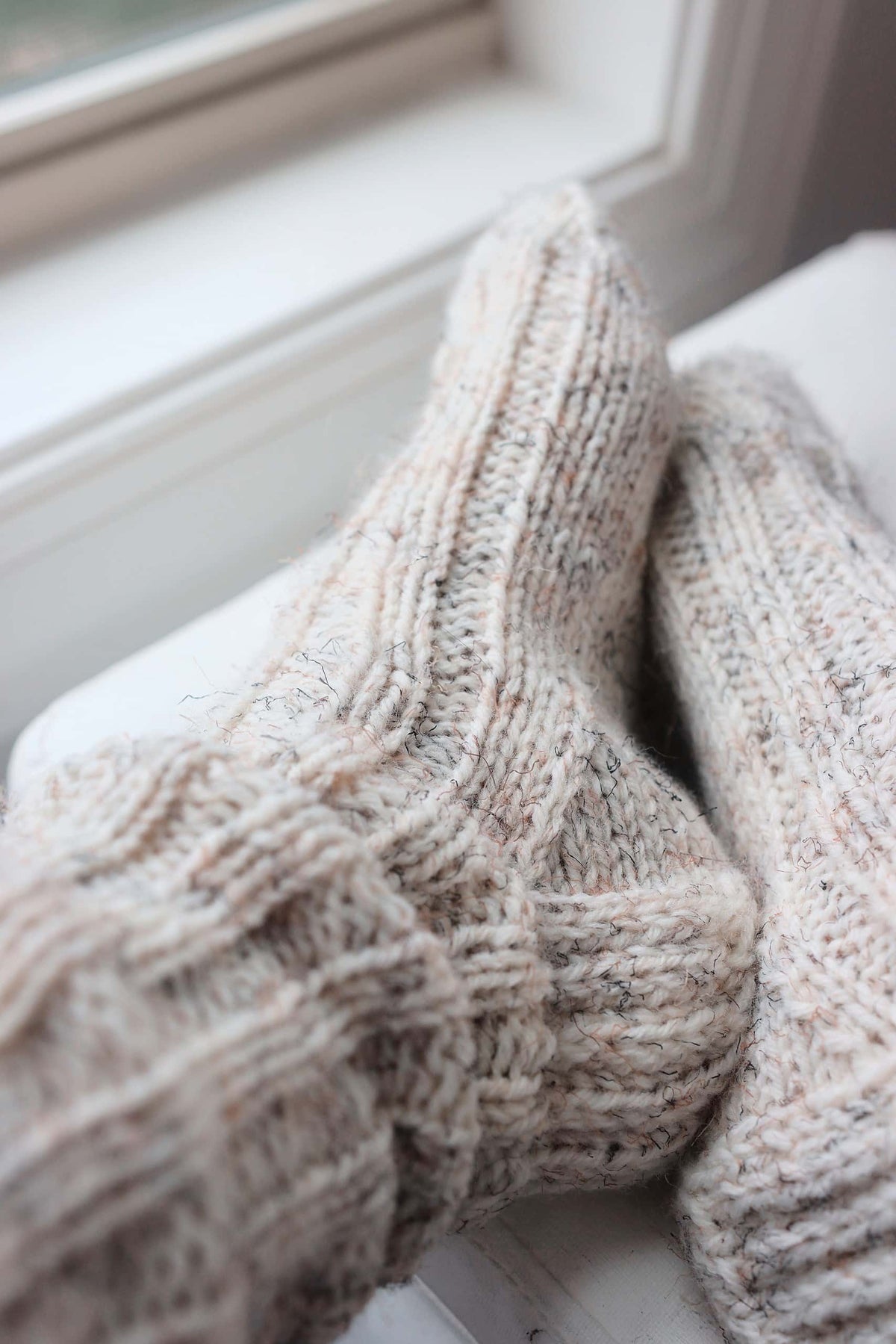 Chunky worsted house socks knitting pattern styled on feet with warm aesthetic
