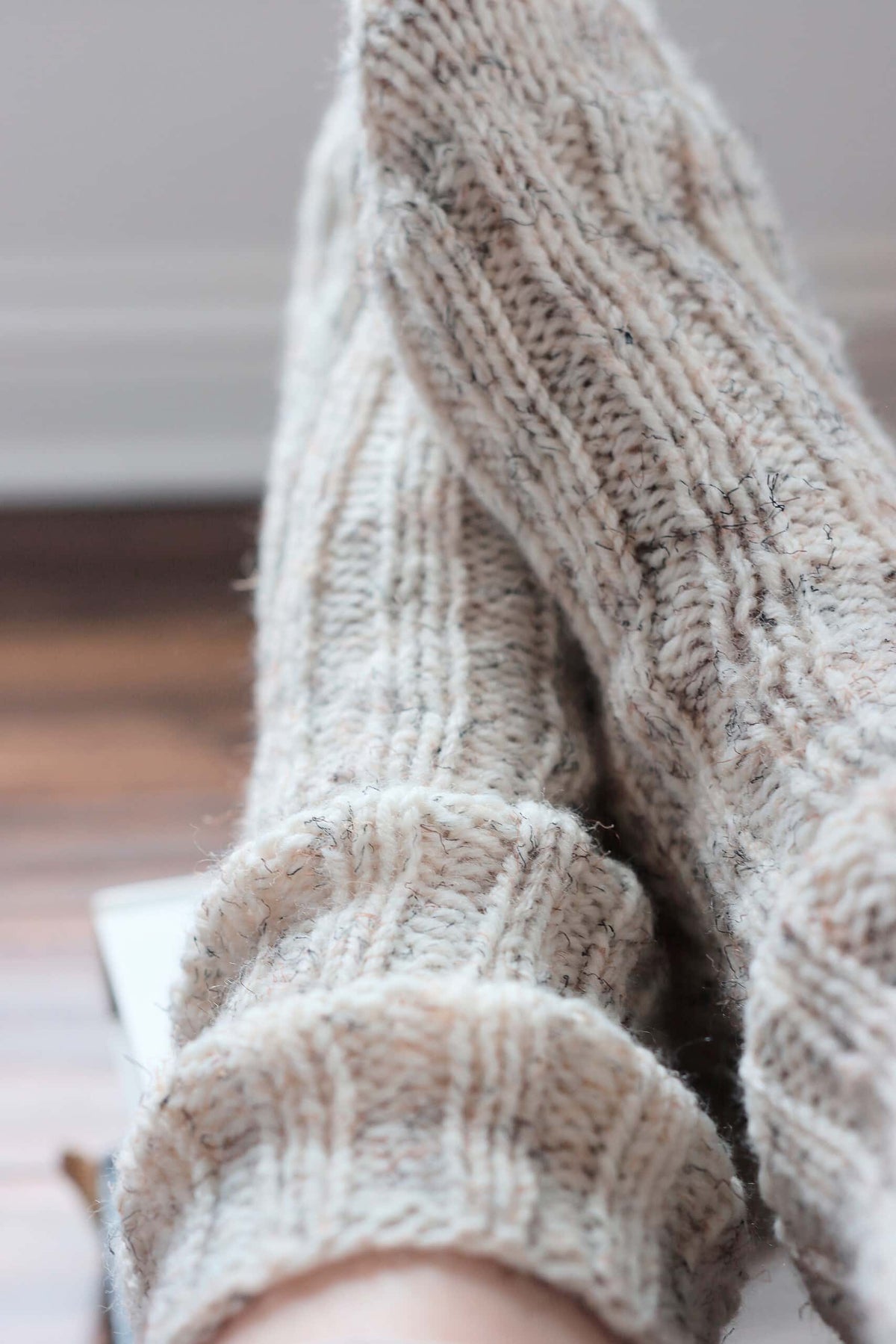Close-up of textured ribbed knit house socks pattern detail in cream yarn