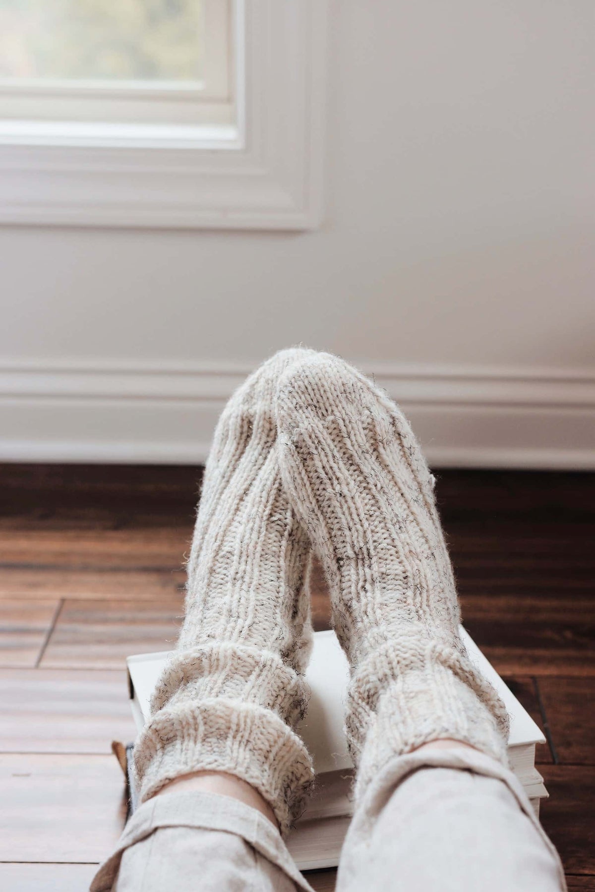 Easy knit house socks pattern in cream showing ribbed cuff and textured design