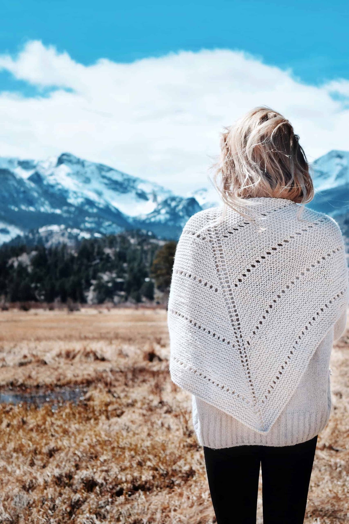 Woman wearing cream Big Cozy triangle shawl with eyelet details over neutral sweater