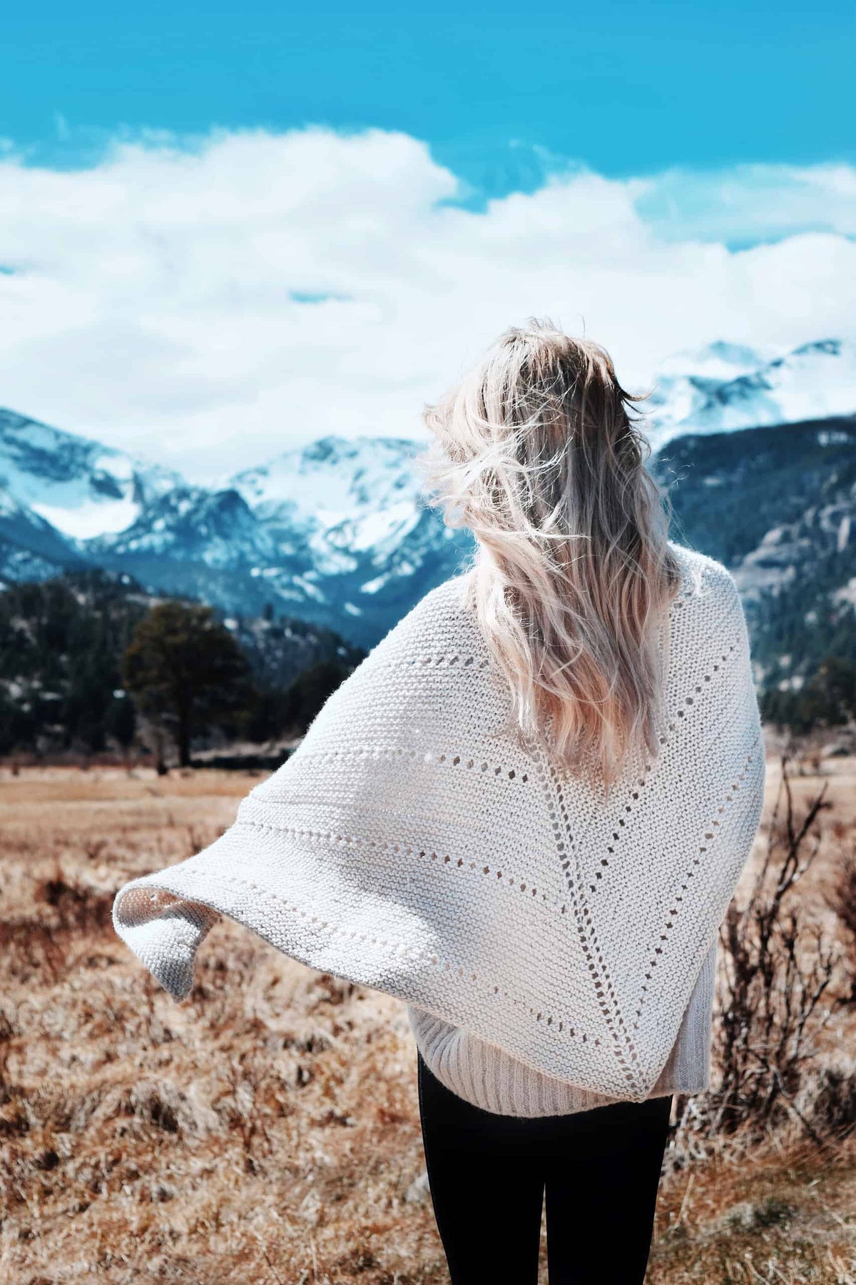 Side view of woman wearing Big Cozy triangle shawl draped over shoulders