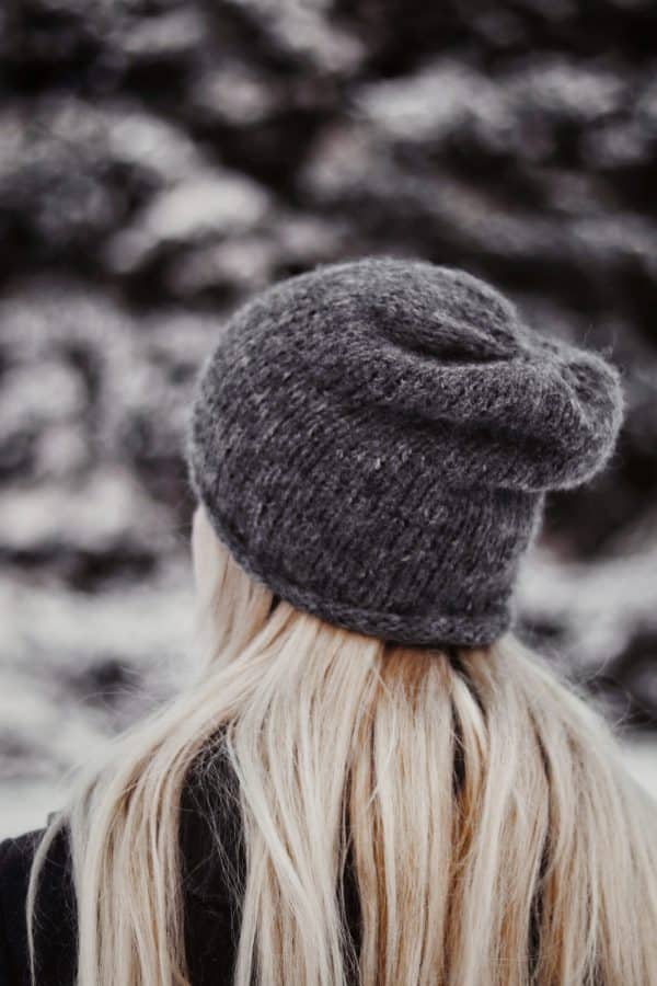 Woman modeling The Hadley Beanie, easy beginner-friendly slouchy beanie knitting pattern
