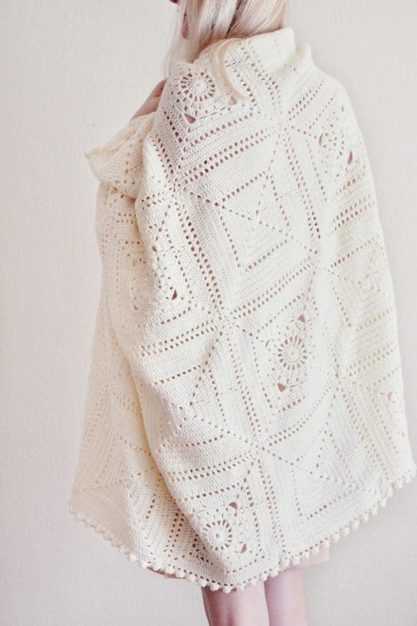 Textured crochet blanket pattern showing detailed lacework and dimensional bobbles in cream yarn