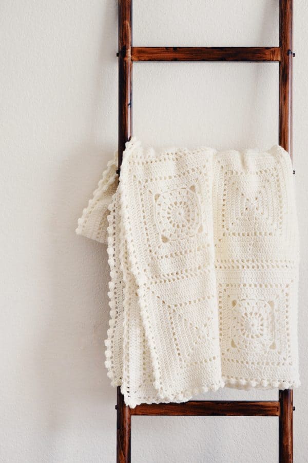 Intermediate crochet throw pattern featuring classic granny square motifs with contemporary texture