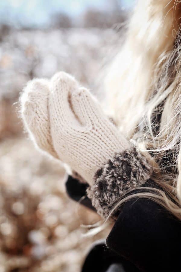 Close up of knitted mittens with plush faux fur cuff detail showing texture and warmth