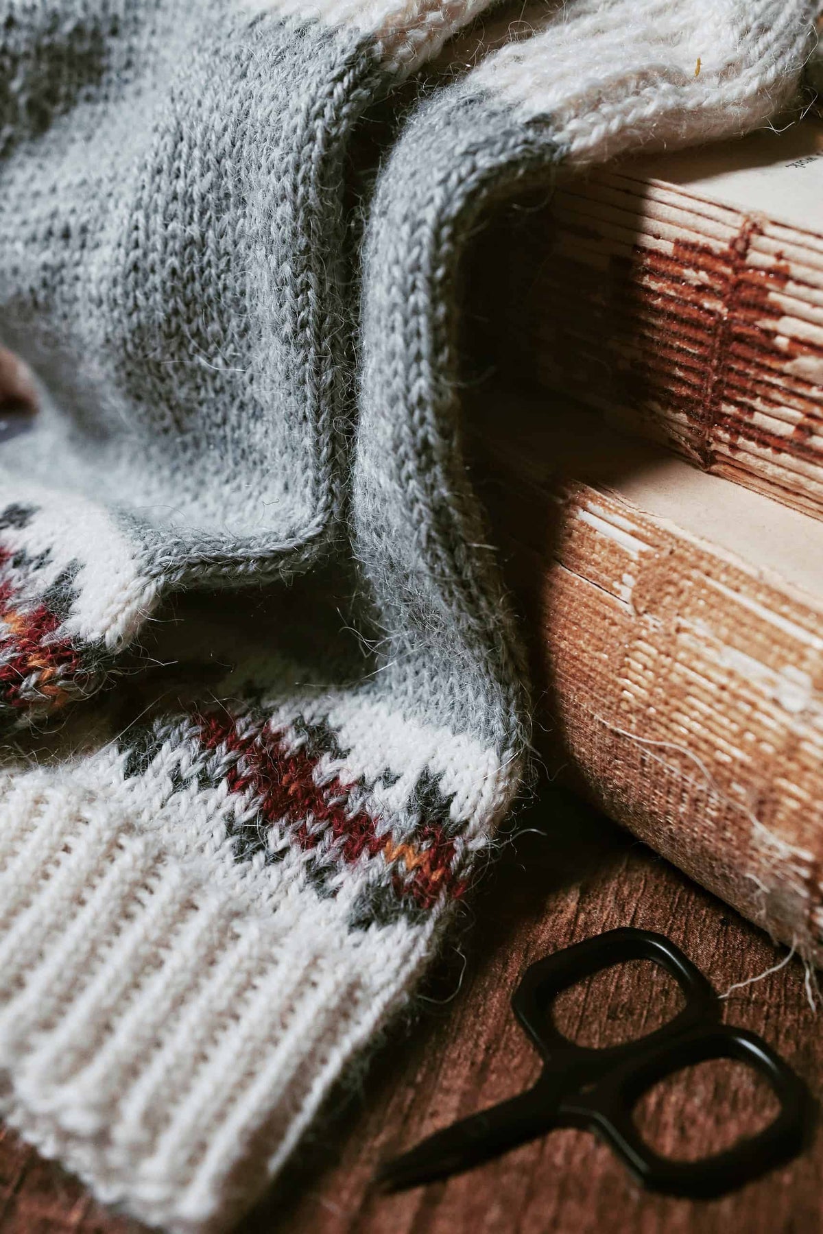 Permafrost socks knitting pattern styled with winter boots and cozy blanket