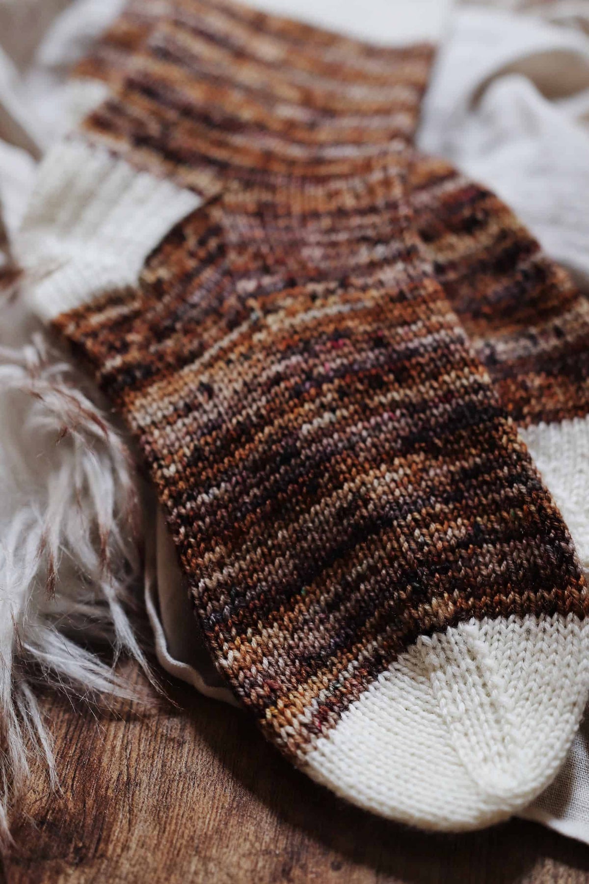 Detail view of Sandstone Socks knit pattern showing variegated color work and ribbing