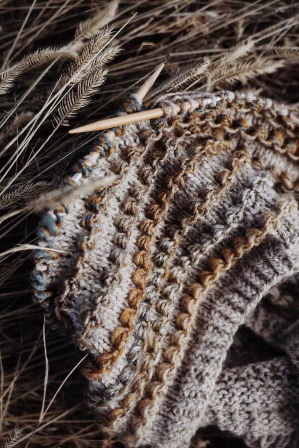 Close-up of textured knit cowl in warm rosewood yarn showing ribbed stitch detail - Rosewood Cowl pattern by Darling Jadore