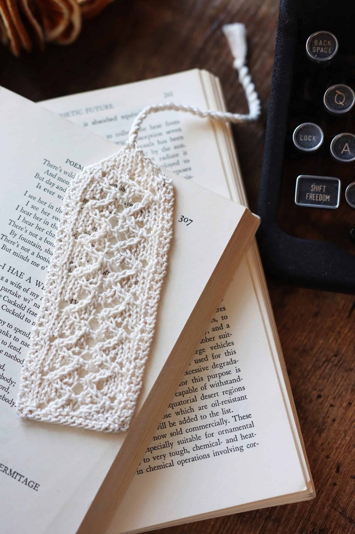 Vintage lace bookmark knitting pattern with swirling delicate design on open book