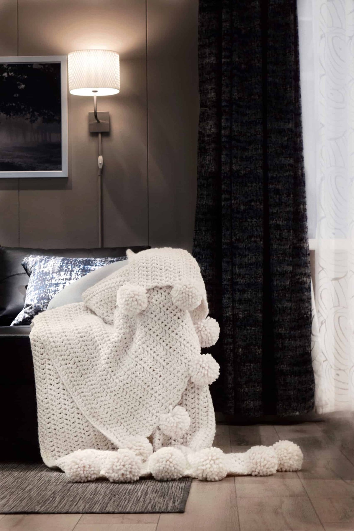 Aspyn throw crochet blanket pattern styled on bed with neutral bedding and cozy home decor