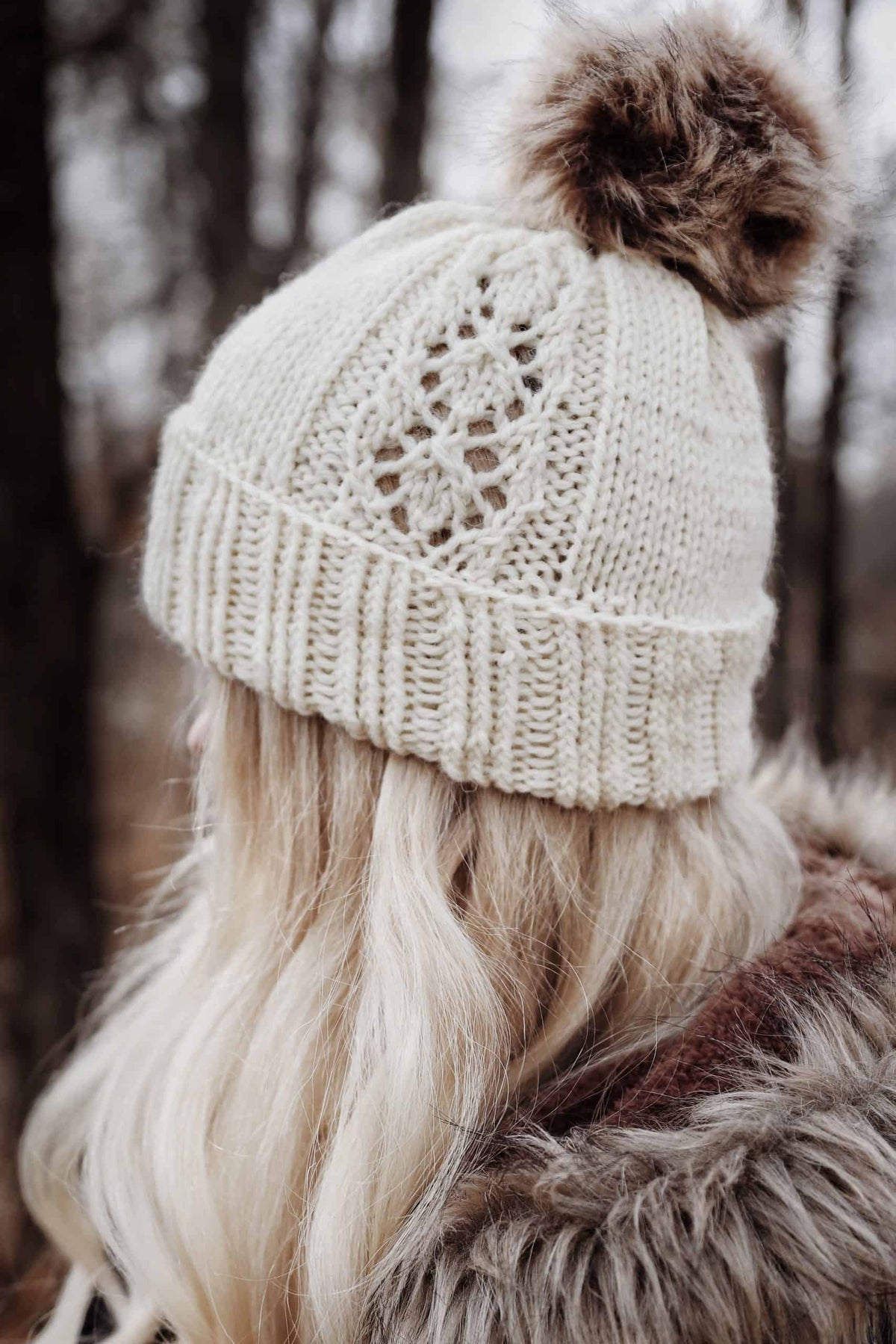 Woman modeling elegant Phlox lace beanie knitting pattern in natural light showing classic silhouette