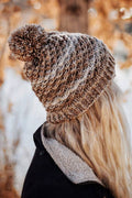 Textured beanie knitting pattern with ribbed brim and pom pom detail shown on model