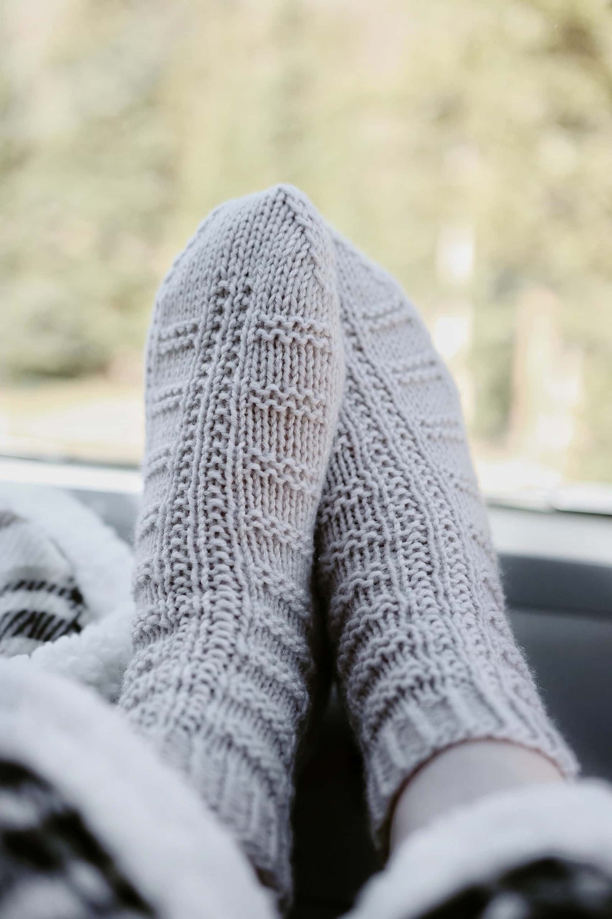 Close up detail of Highland socks knitting pattern textured stitch work in cream yarn