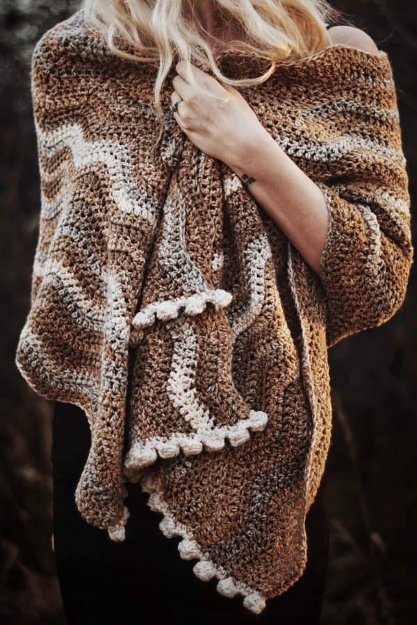 The Riverbed Scarf crochet pattern in earth tone waves with bobble edge detail worn as cozy winter accessory