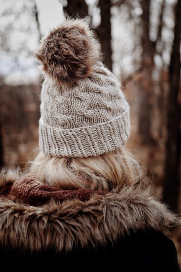 Woman wearing cream cable knit beanie pattern with cozy winter styling