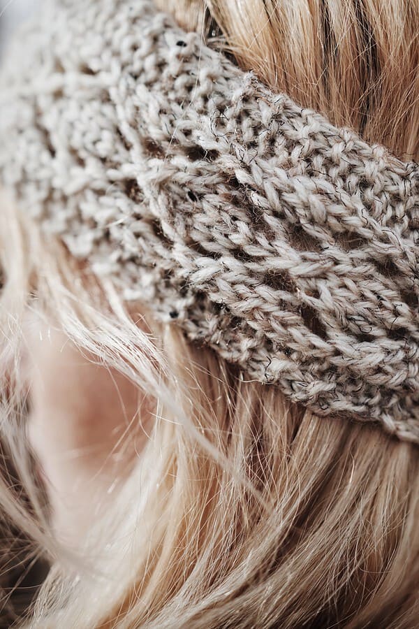 Close-up of lace headband knitting pattern showing intricate flower-esque lace design