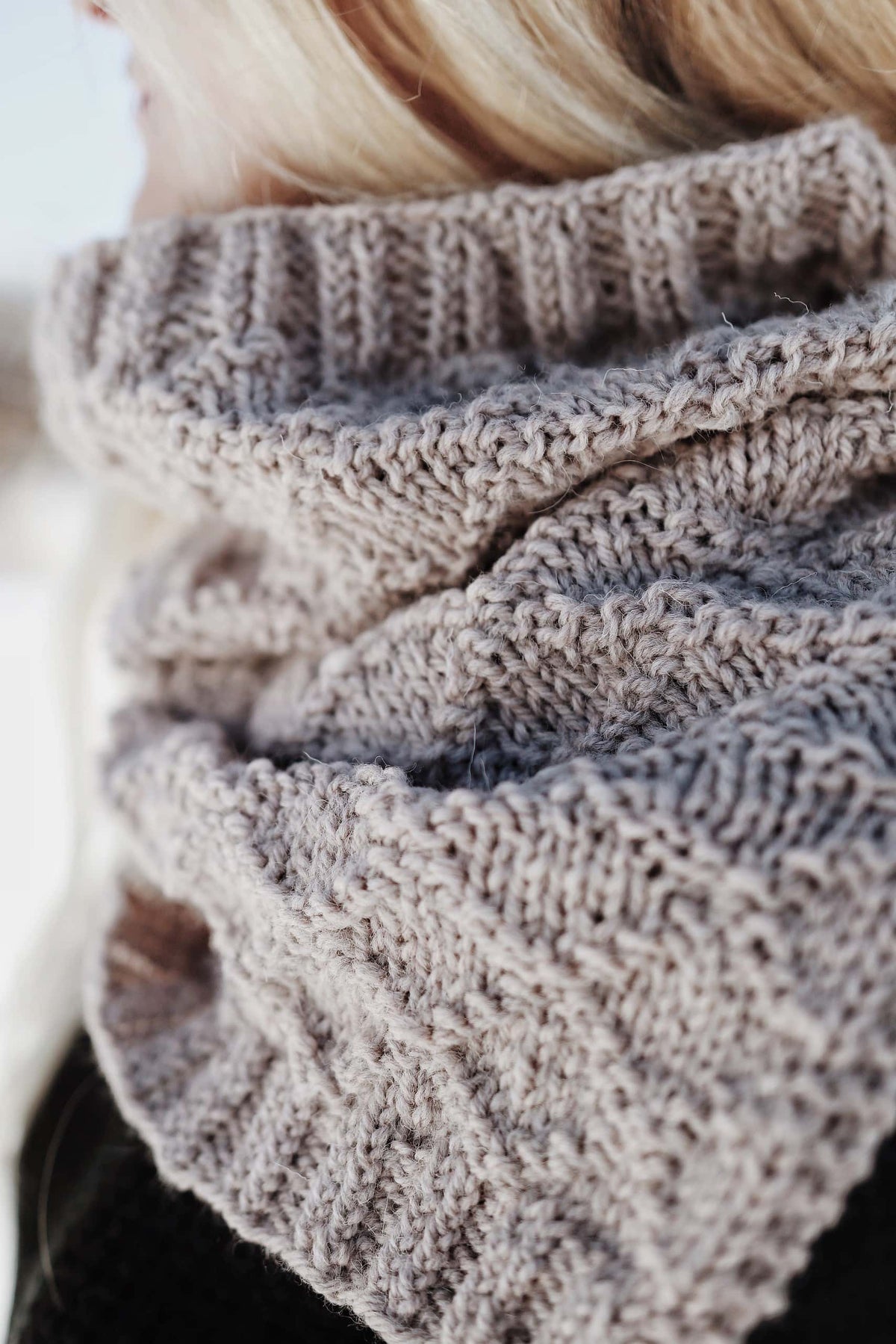 Woman wearing The Harbor Cowl showing elegant drape and split hem cowl design