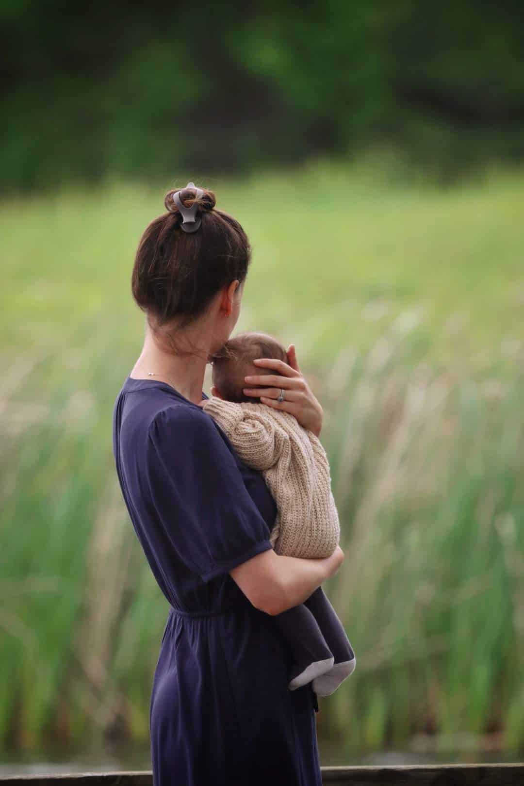 Handknit baby pullover sweater in soft cream yarn with classic raglan construction