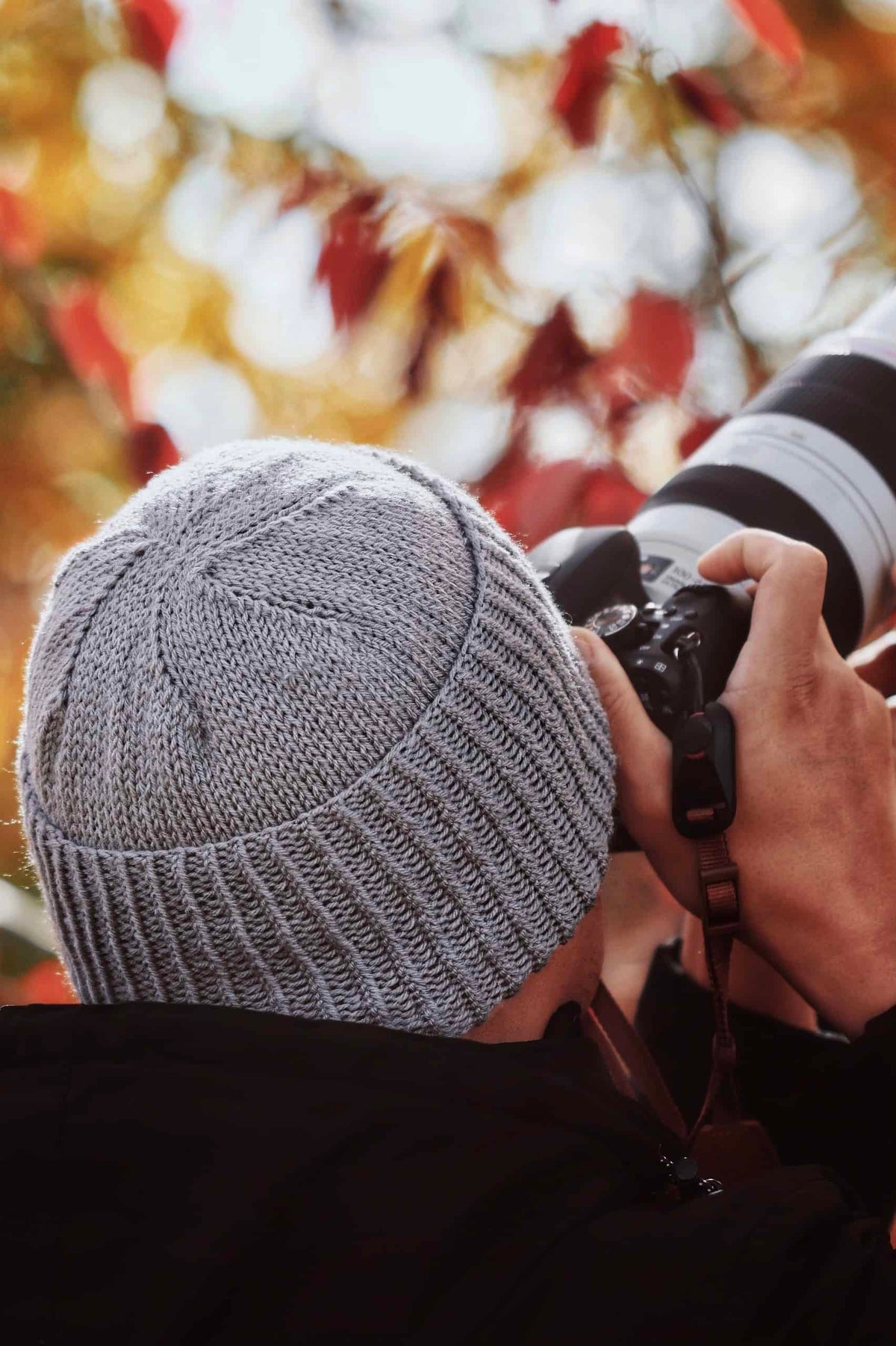Classic men's beanie knitting pattern in neutral yarn worn by model outdoors