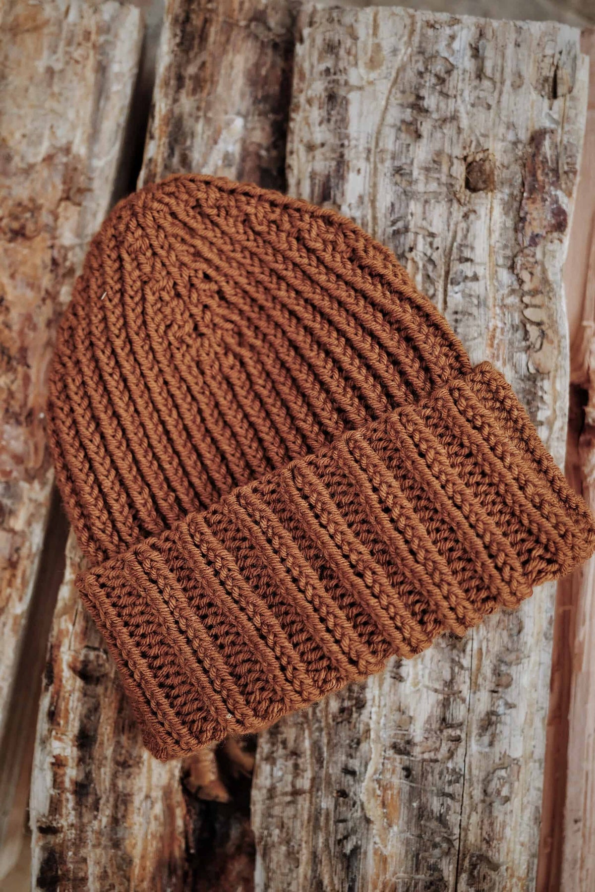 Side view of classic mens beanie knitting pattern in warm brown tone