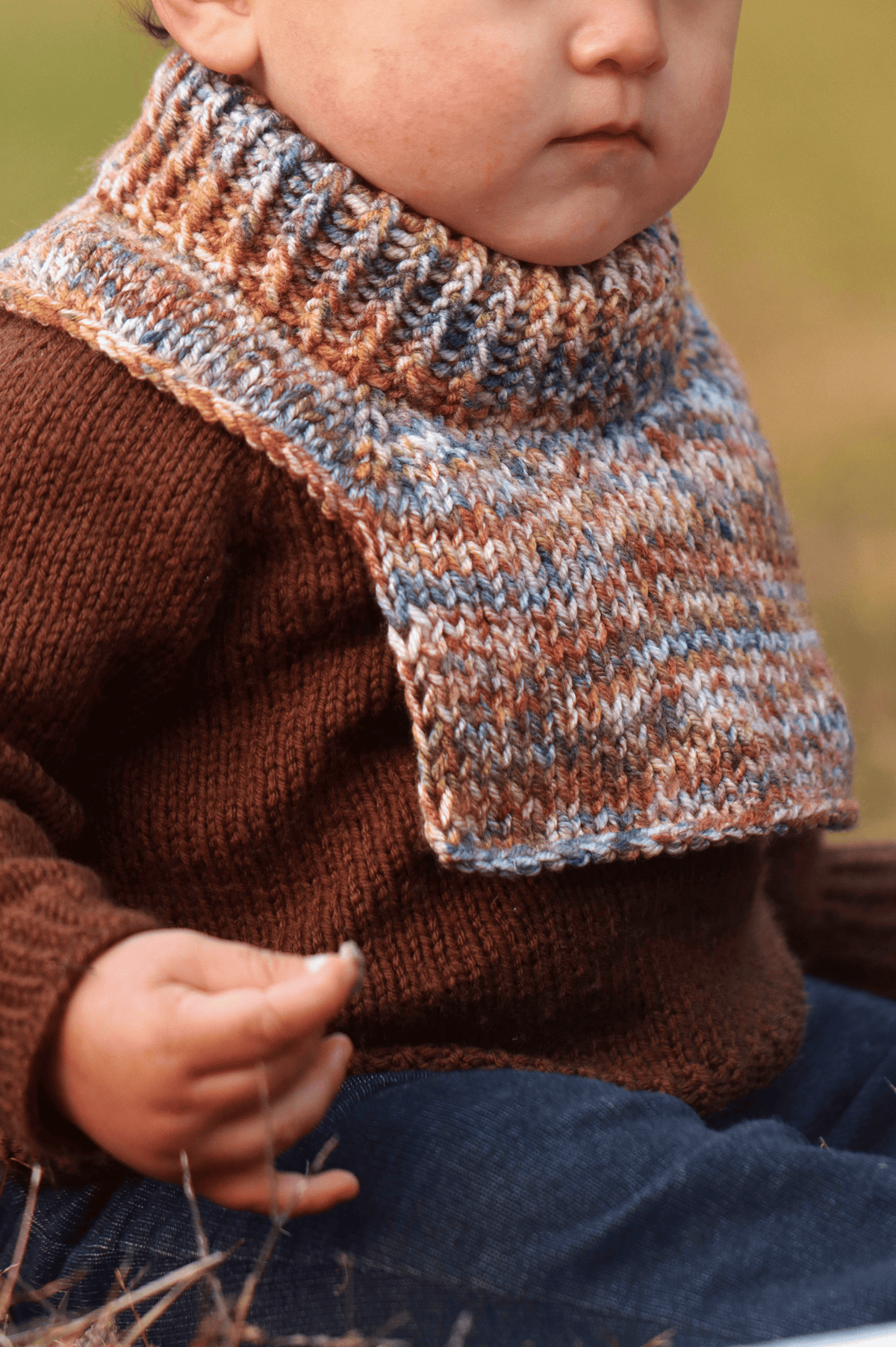 Back view of cream colored knit toddler dickey with wooden button detail