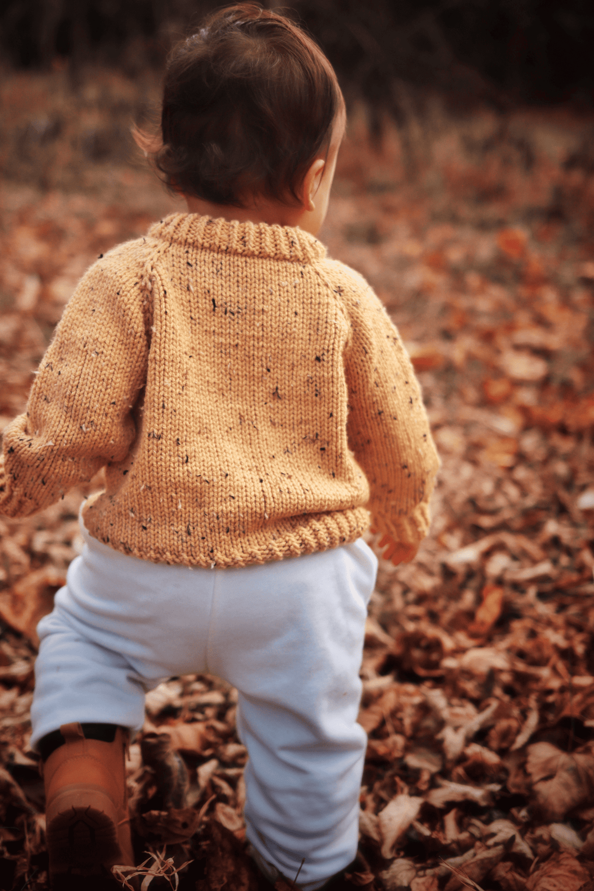 Full view of toddler in cream raglan sweater knitting pattern - sizes 1T, 2T, and 3T available