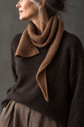 Brown knit scarf draped over a dark sweater - The Skysong Scarf Knitting Pattern by Darling Jadore