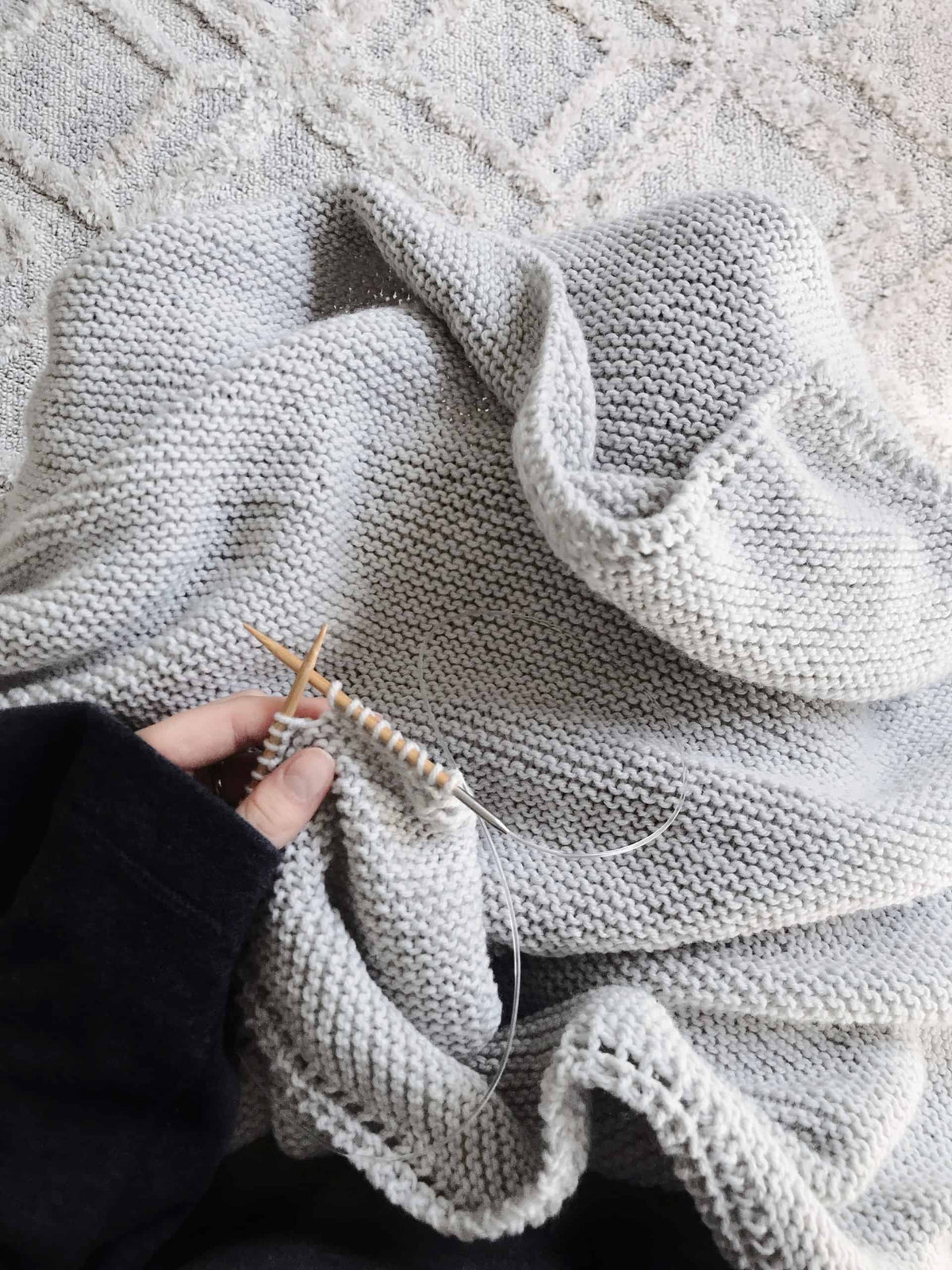 Classic knit baby blanket pattern draped naturally showing cozy garter stitch detail