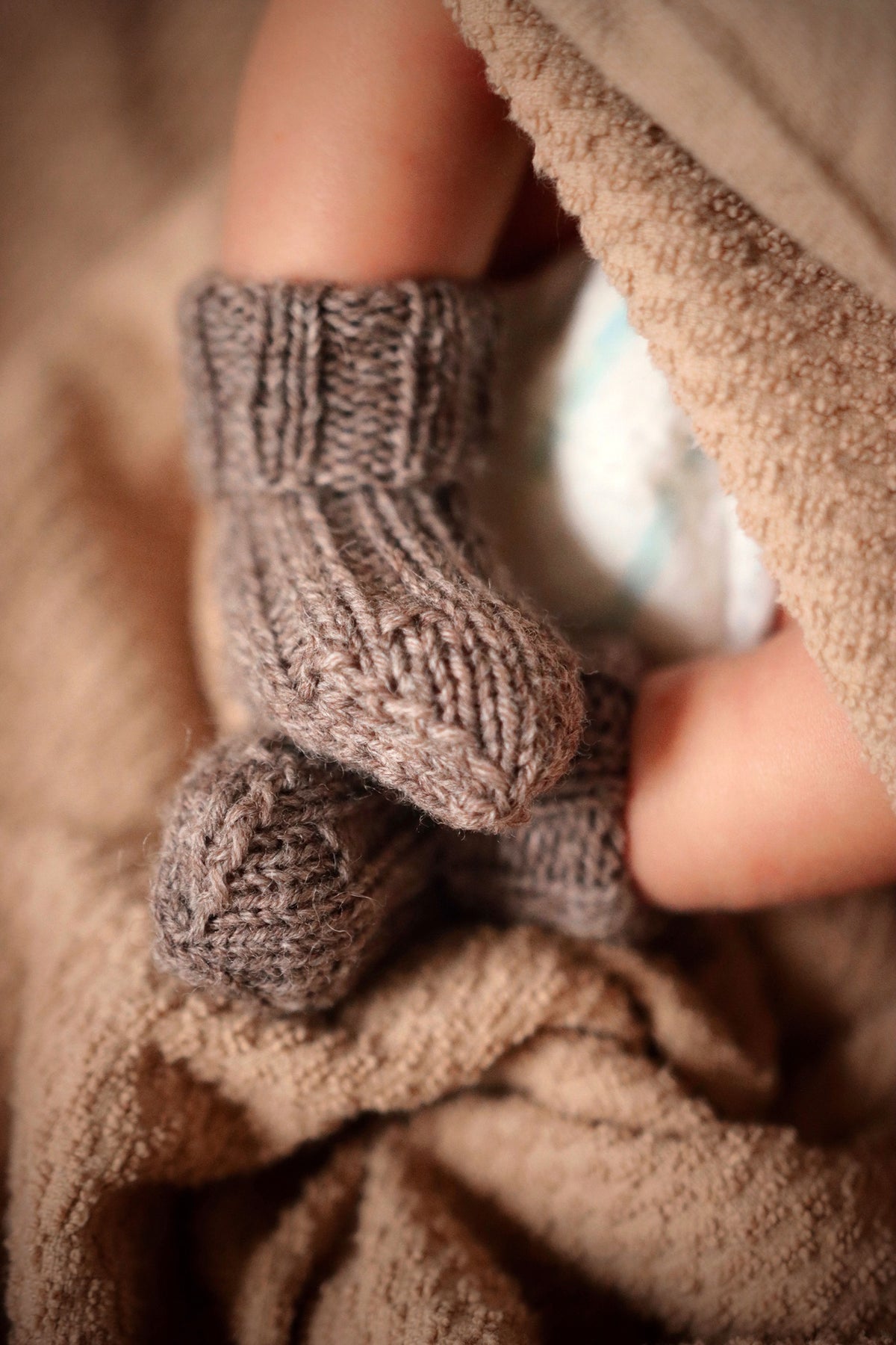 Cozy hand-knit baby socks in soft pastel yarn