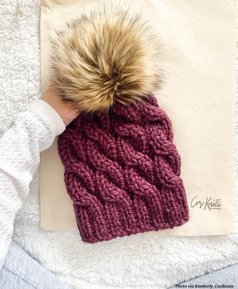 Avalon cable beanie knitting pattern flat lay showing chunky knit texture and pom pom