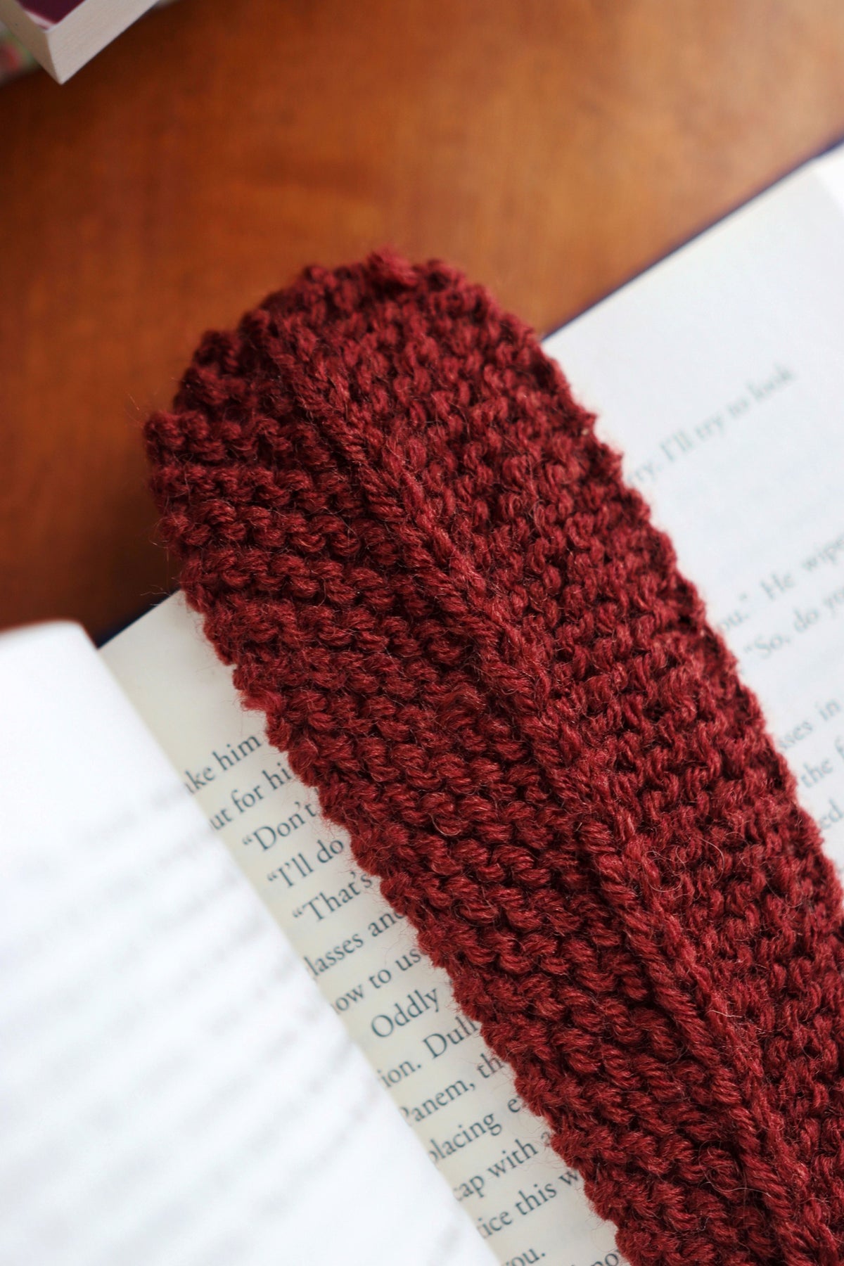 Close up of handmade feather bookmark knitting pattern showing organic texture and gentle stitches