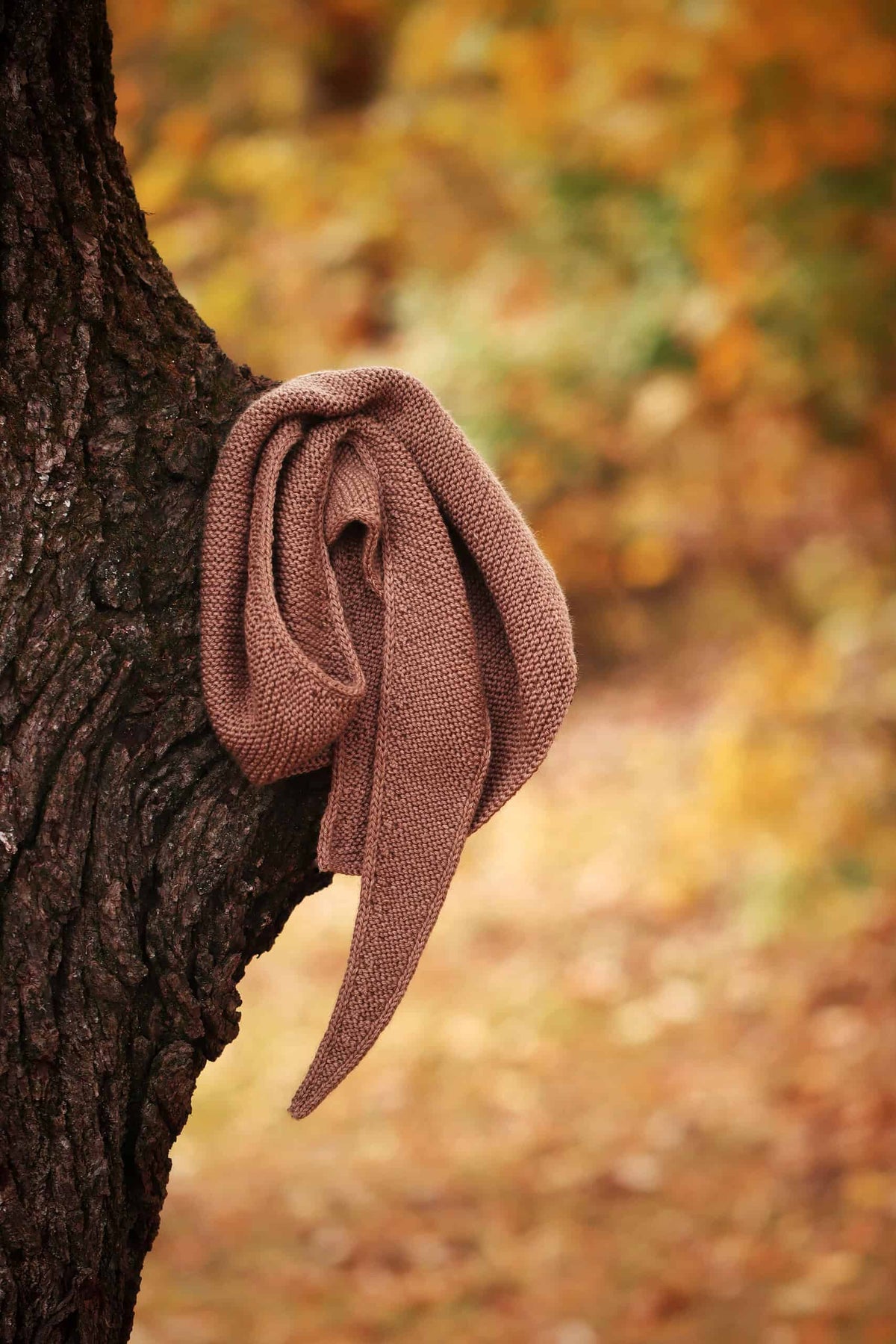 Brown asymmetrical scarf knit pattern with refined edge detail and natural drape