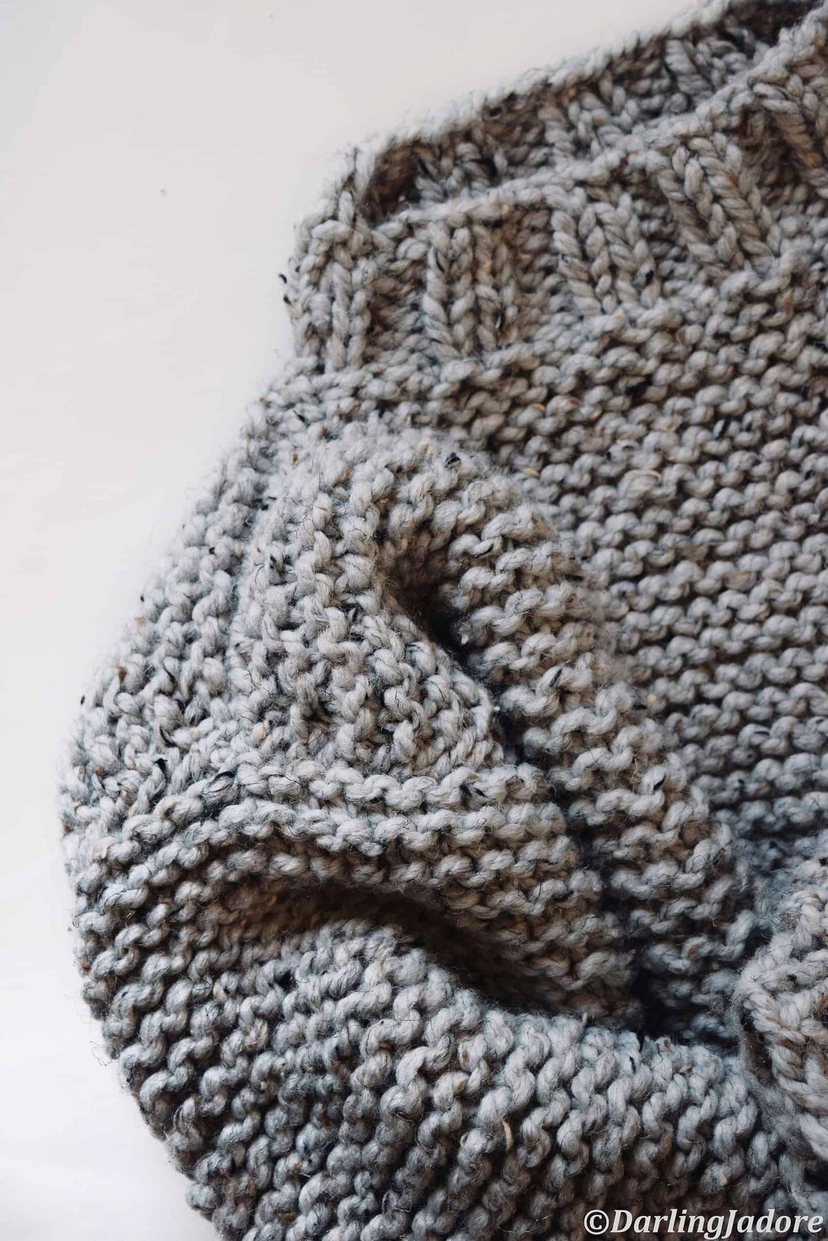 Woman in cozy Campfire Sweater, easy beginner sweater knitting pattern in cream bulky yarn