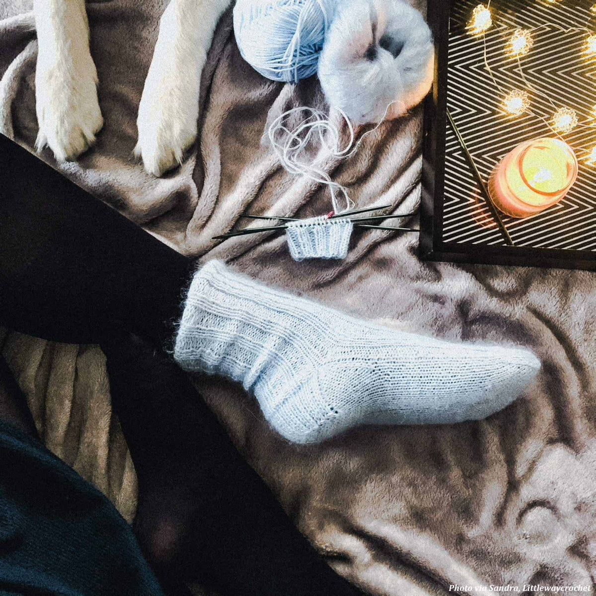 The Cozy Socks knitting pattern cover showing finished cream ribbed socks