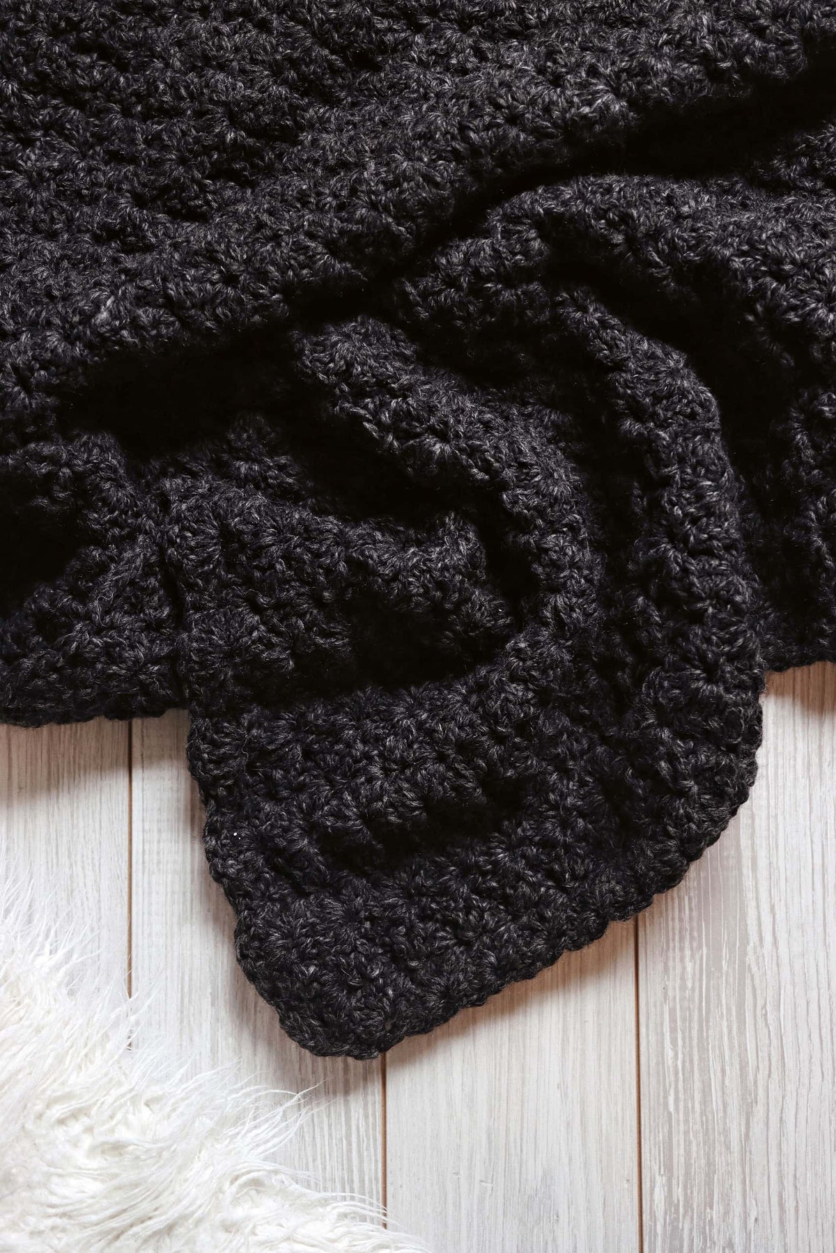 Easy crochet afghan pattern with chunky yarn showing cozy textured scallop design