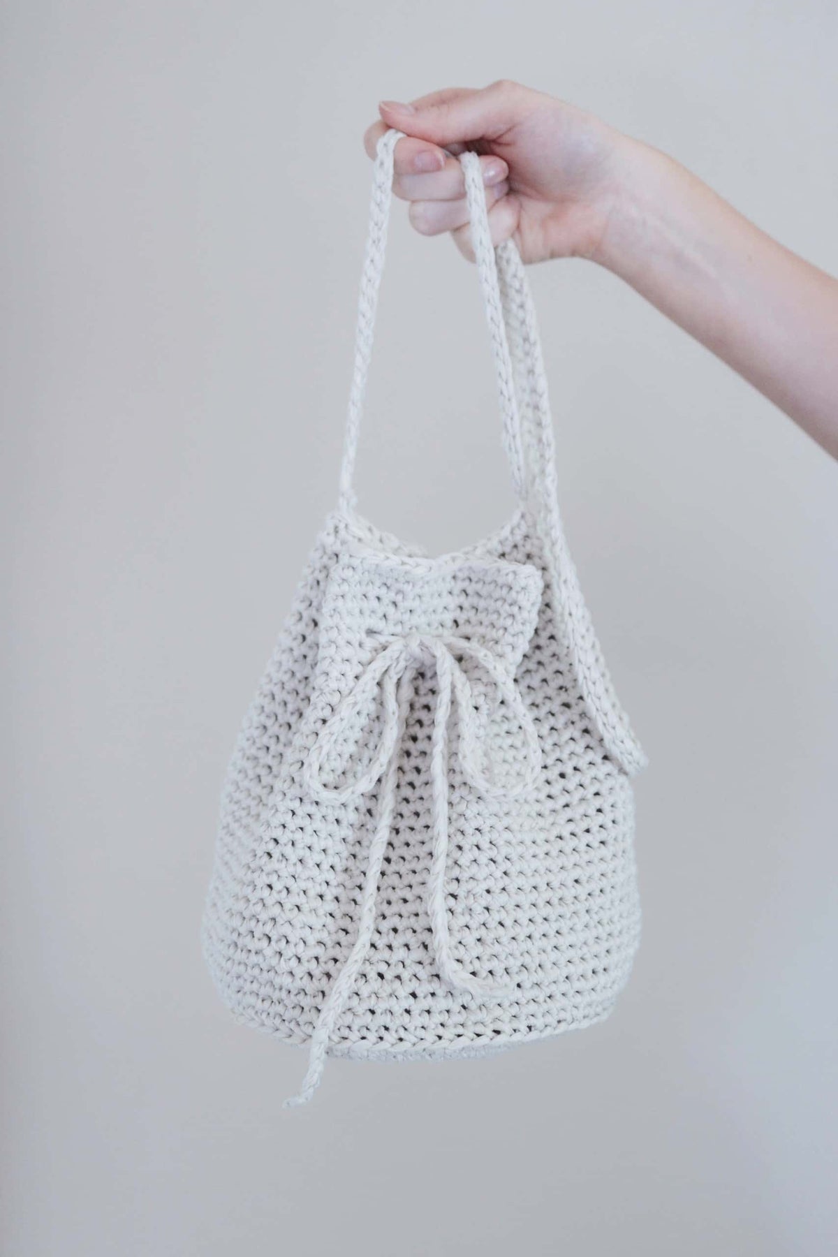 Easy drawstring bucket bag crochet pattern styled with summer outfit