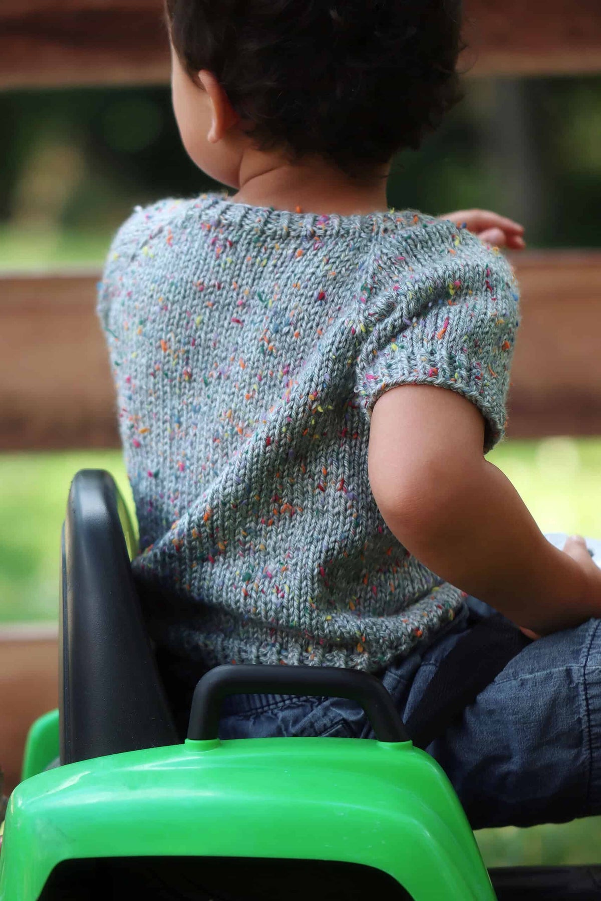 Toddler wearing cream stockinette baby sweater knitting pattern by Darling Jadore