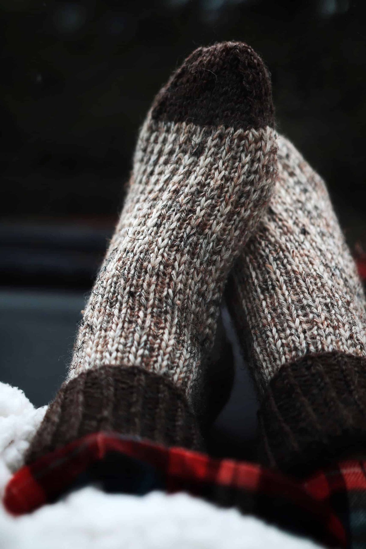 Close up of chunky knit socks pattern showing detailed stitch work and ribbed cuff