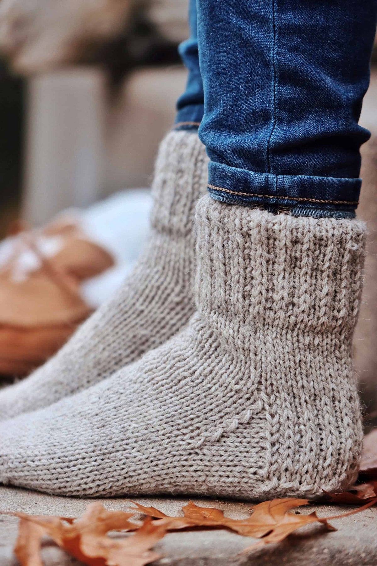 Worsted weight slipper socks knitting pattern in cream yarn with double-knit cuff