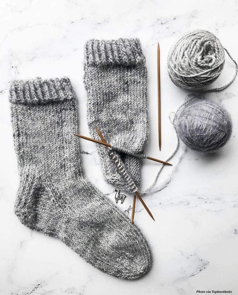 The Feather Socks knitting pattern cover showing luxurious mohair socks in warm neutral tones