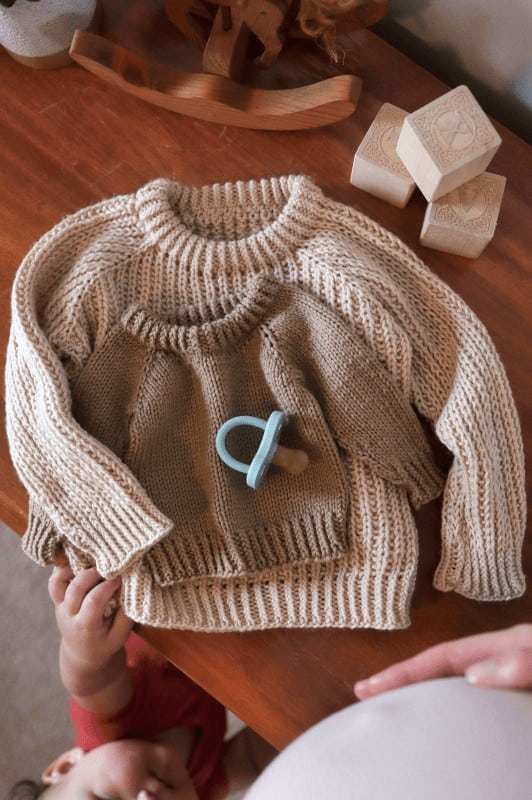 Cozy knitted baby pullover sweater in cream fisherman rib stitch