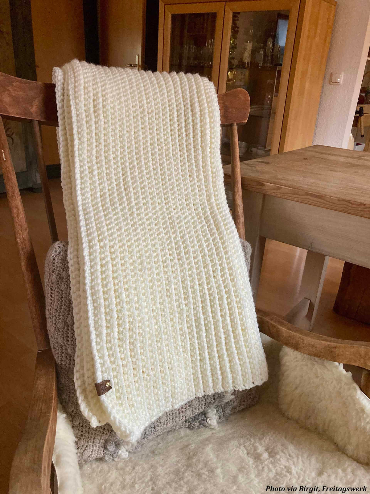 Fireside throw crochet blanket displayed near fireplace for cozy ambiance