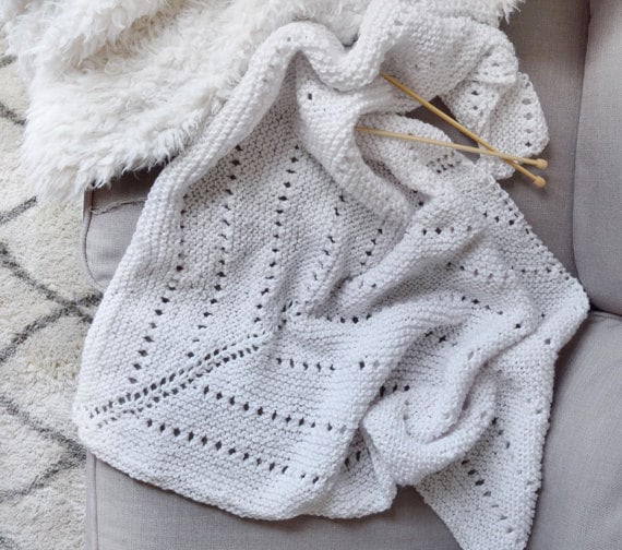 Flat lay of cream triangle shawl showing full cozy drape and shape