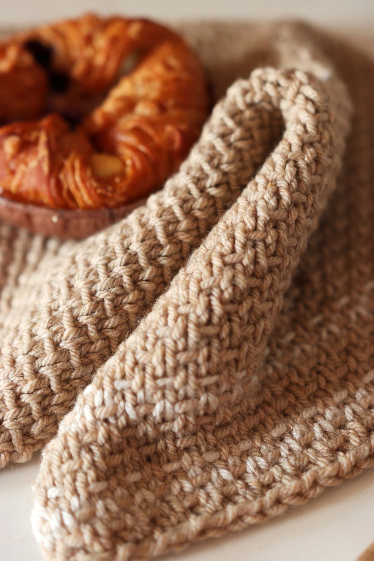 Cream knitted kitchen towel with textured stitch pattern hanging in farmhouse kitchen - Homestead Towel pattern by Darling Ja