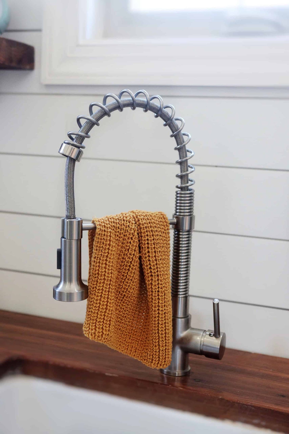 Hand-knitted sustainable kitchen towel displayed on countertop showing absorbent textured fabric