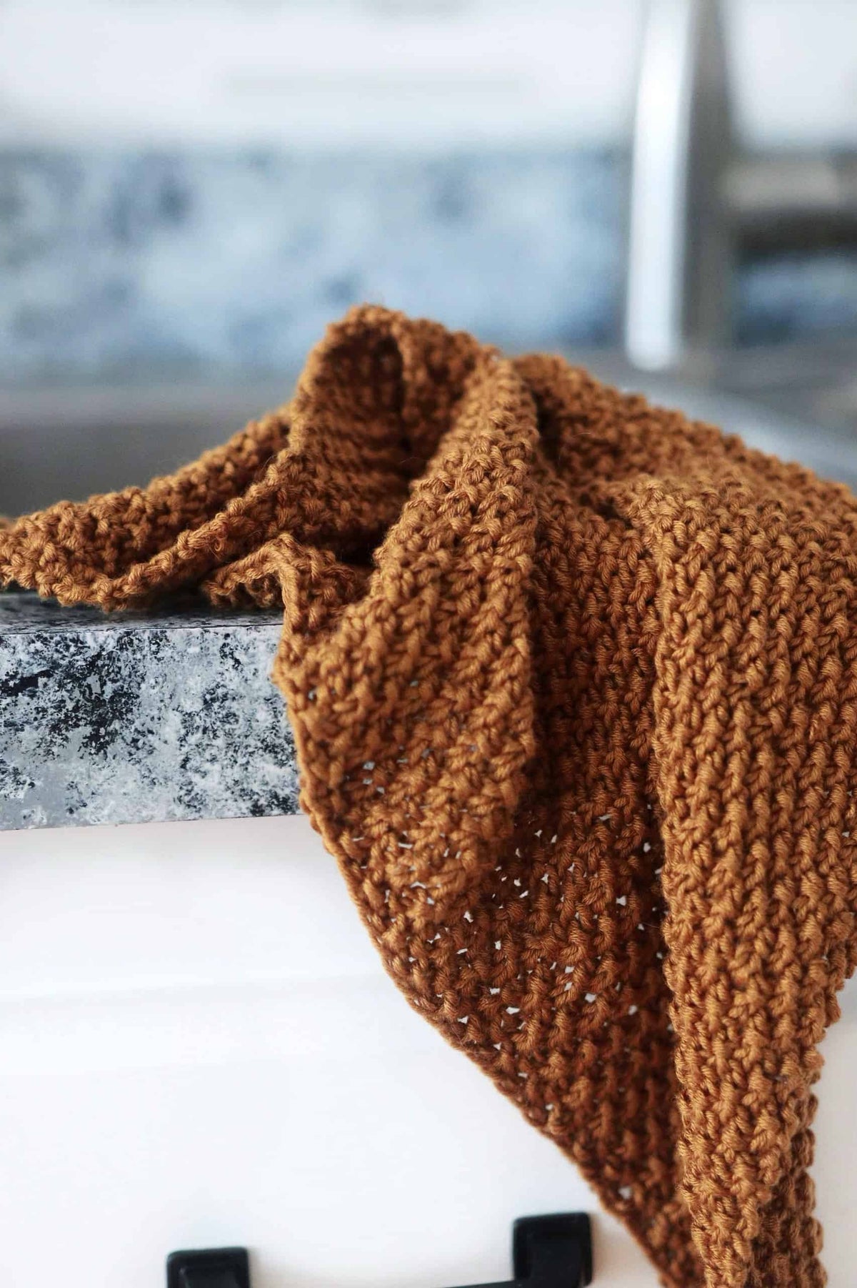 Reversible knitted kitchen towel with all-over texture pattern displayed in minimalist kitchen setting