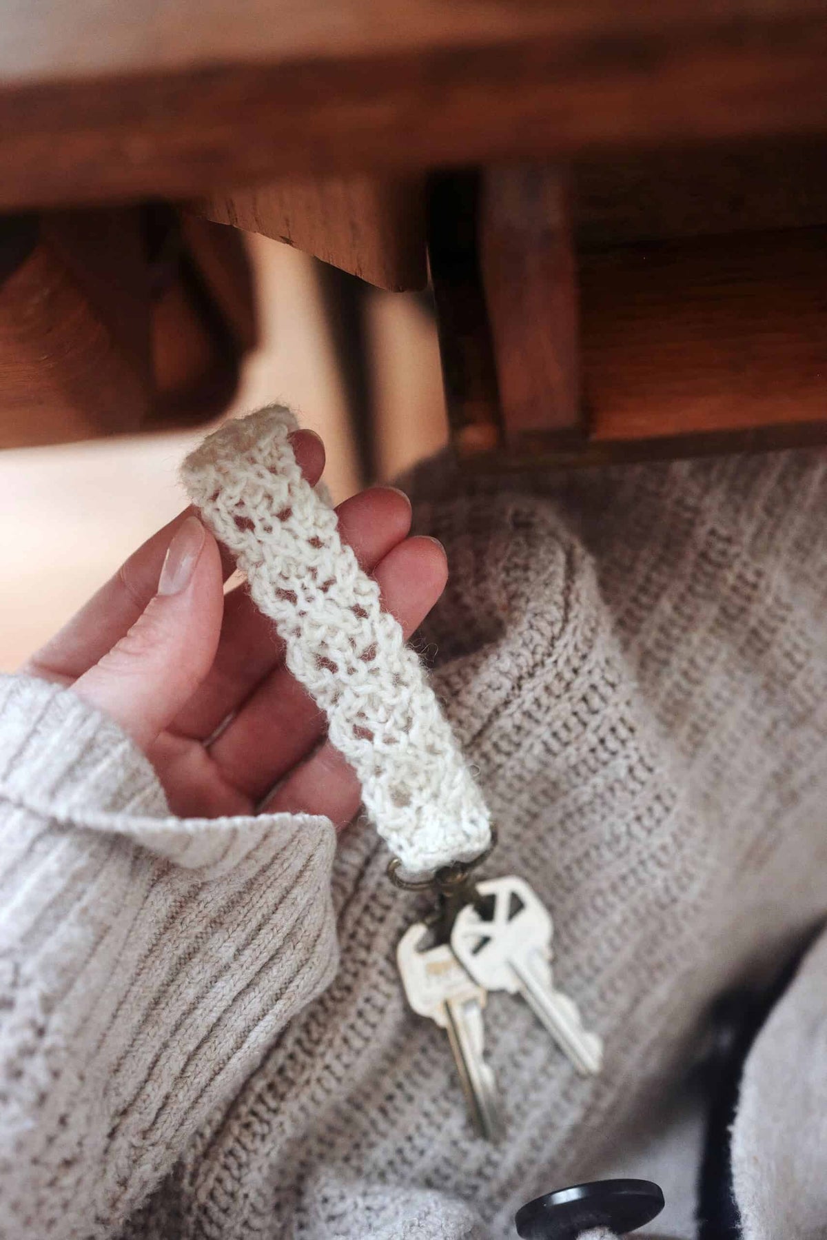Lace knit keychain with tassel in cream yarn attached to keys - handmade knitting pattern accessory by Darling Jadore