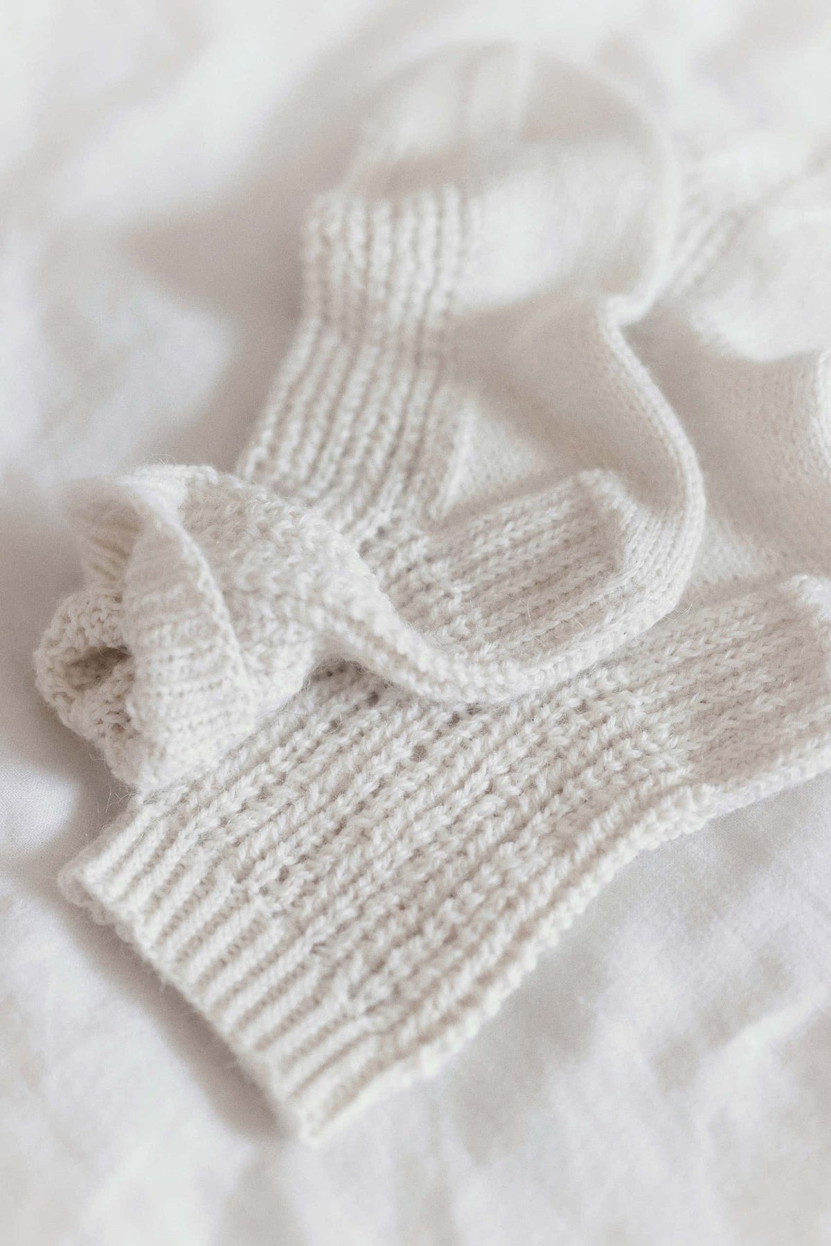 Detailed view of lace socks knitting pattern with swirling snow-inspired lacework design