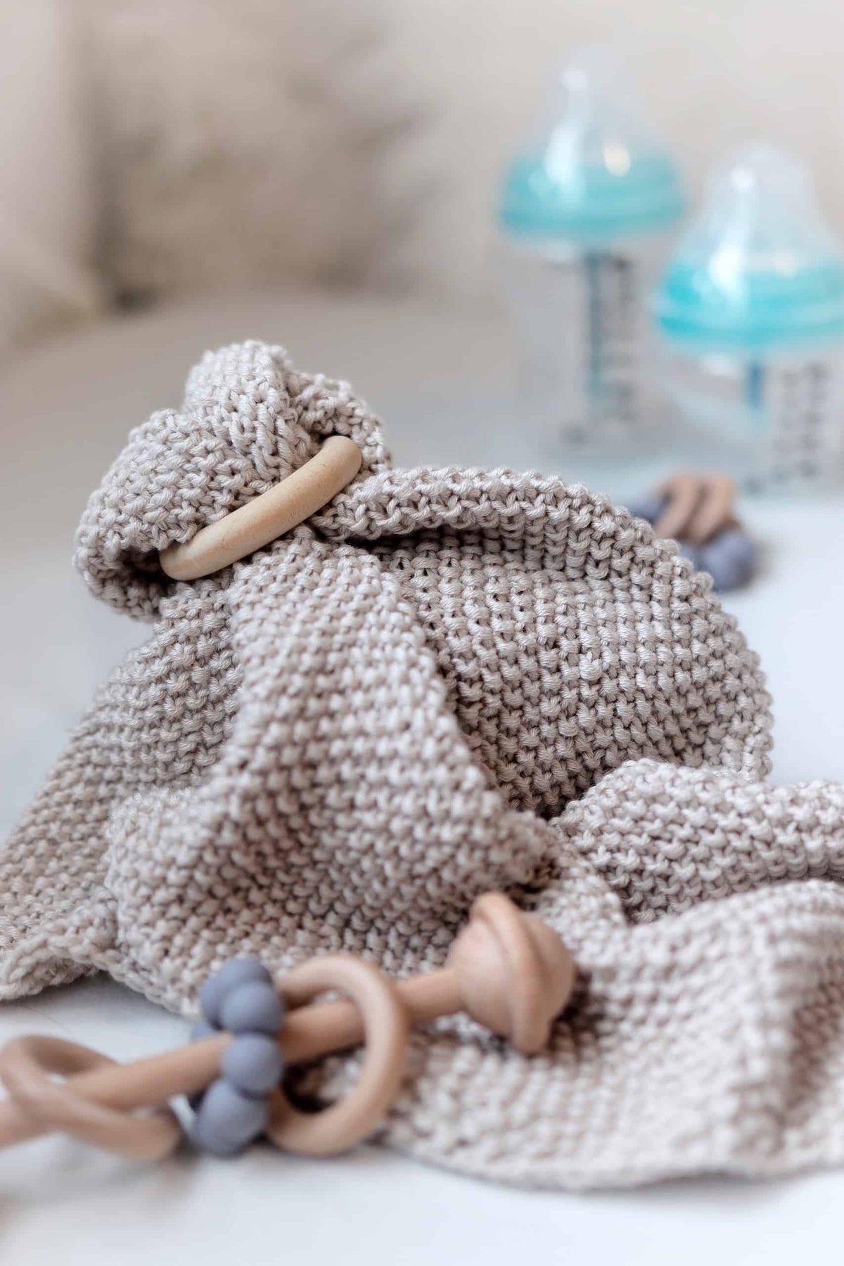 Hand knit baby lovey blanket in soft cream yarn showing reversible texture